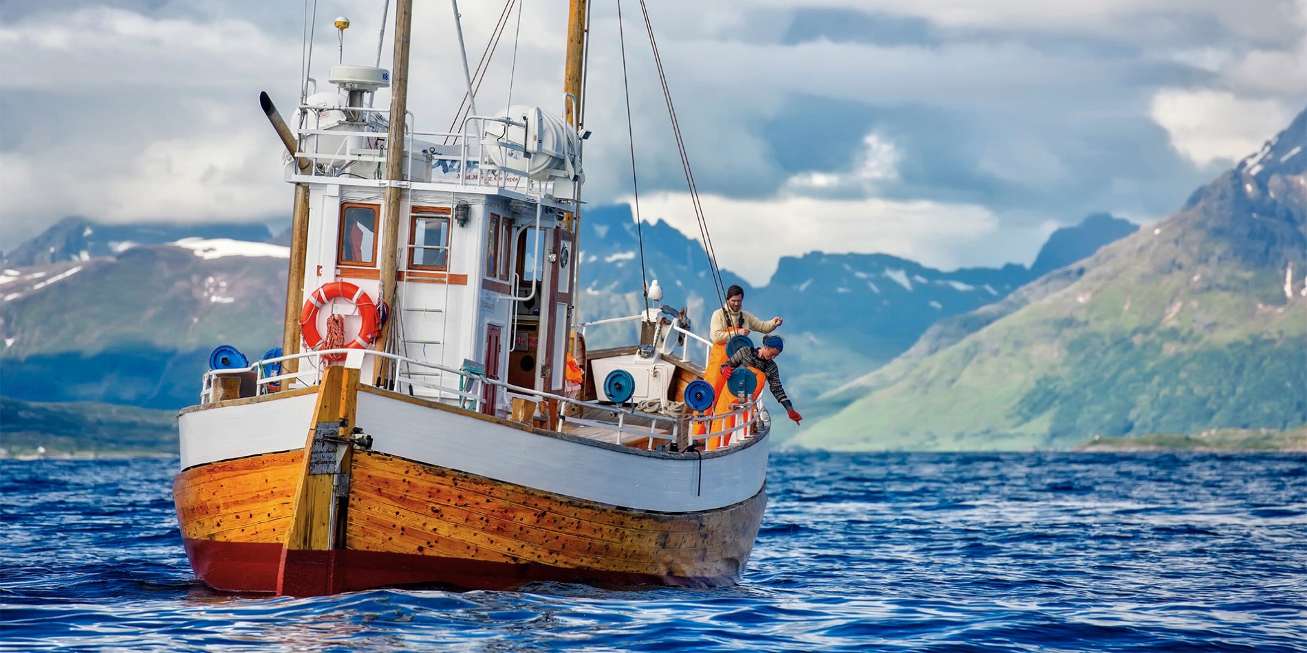 En fiskerbåd med to fiskere i Nordnorge