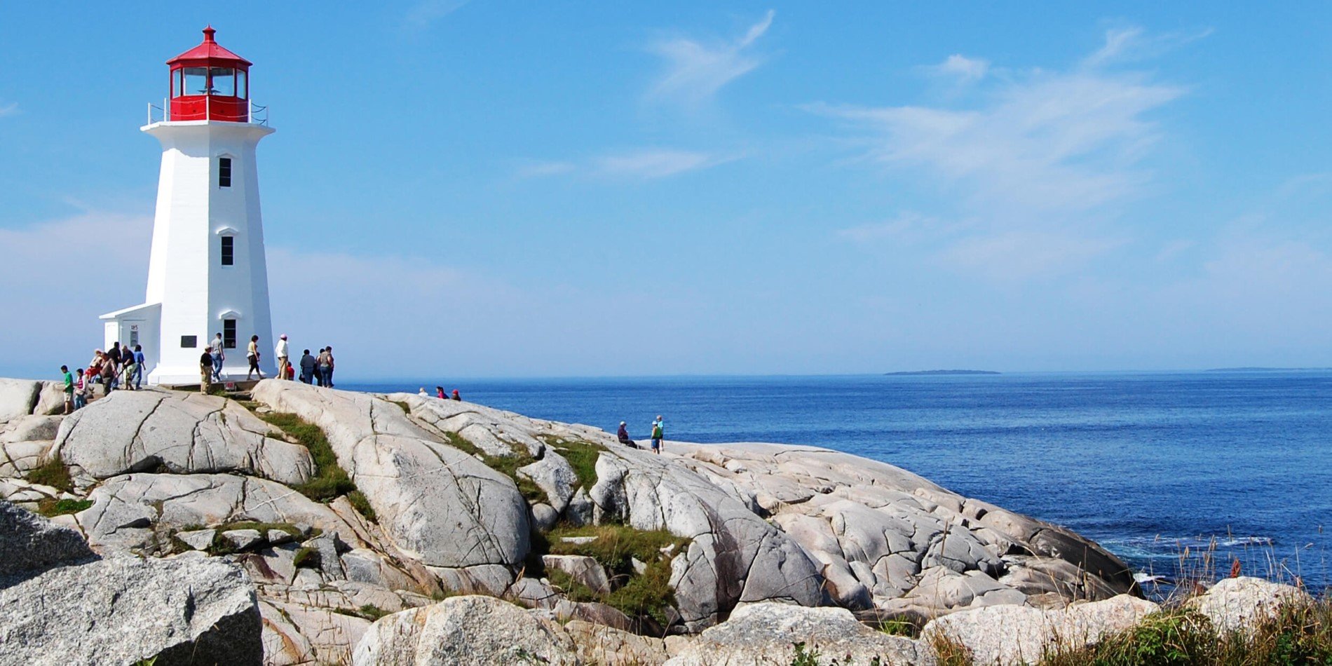 En statue af en person, der sidder på en klippe nær havet