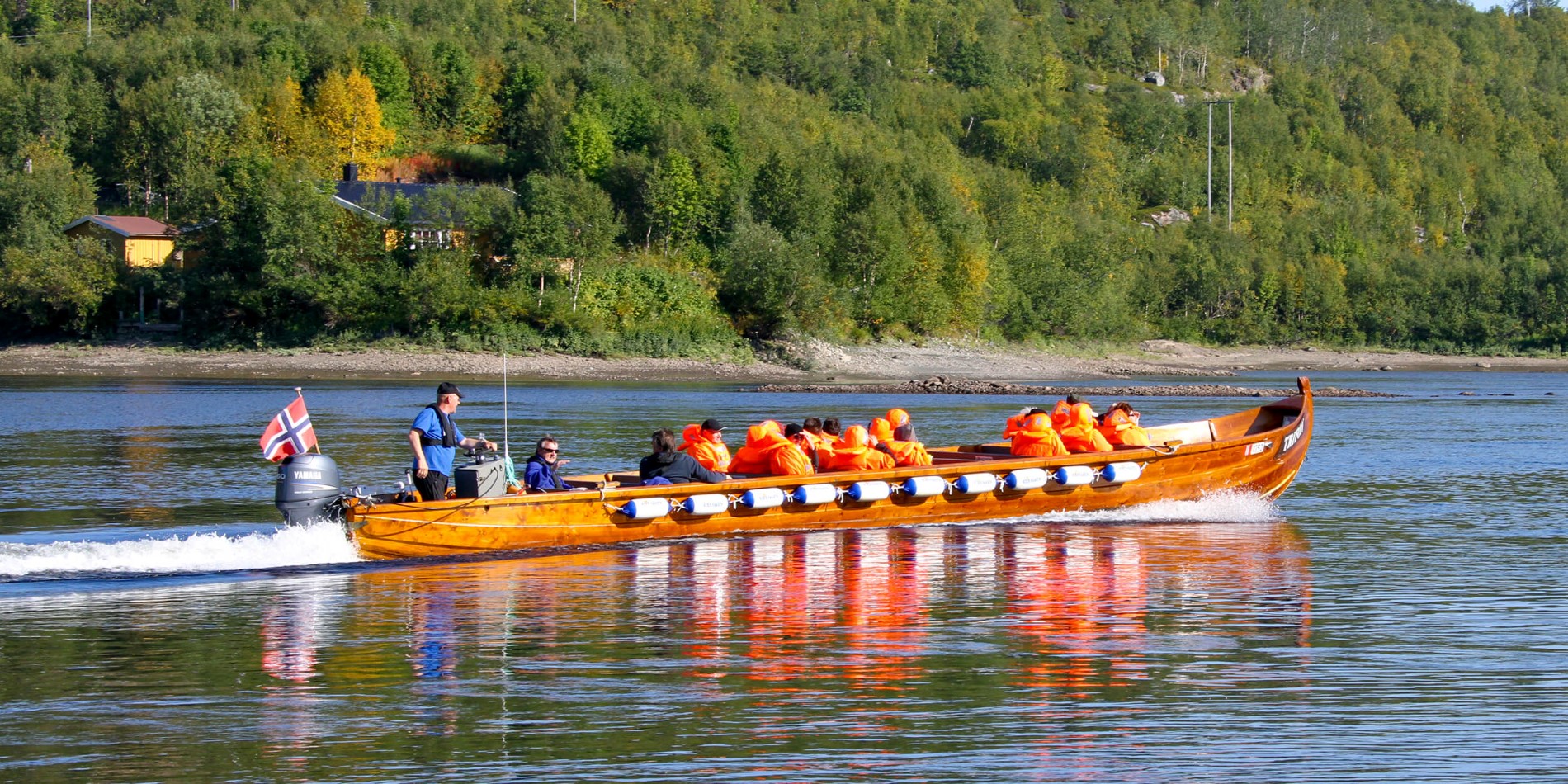 En gruppe mennesker, der rider på bagsiden af en båd i vandet