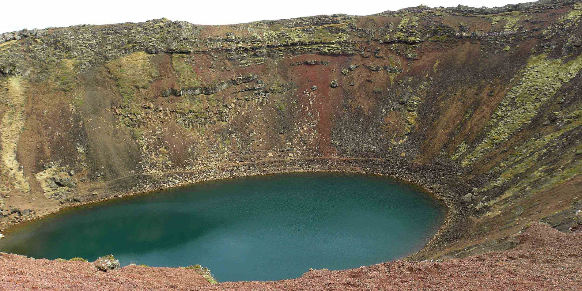 Vand ved siden af klippen med stort hul i baggrunden