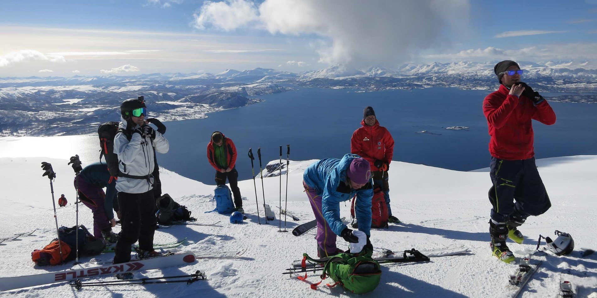 En gruppe mennesker, der Rider ski på toppen af et snedækket bjerg
